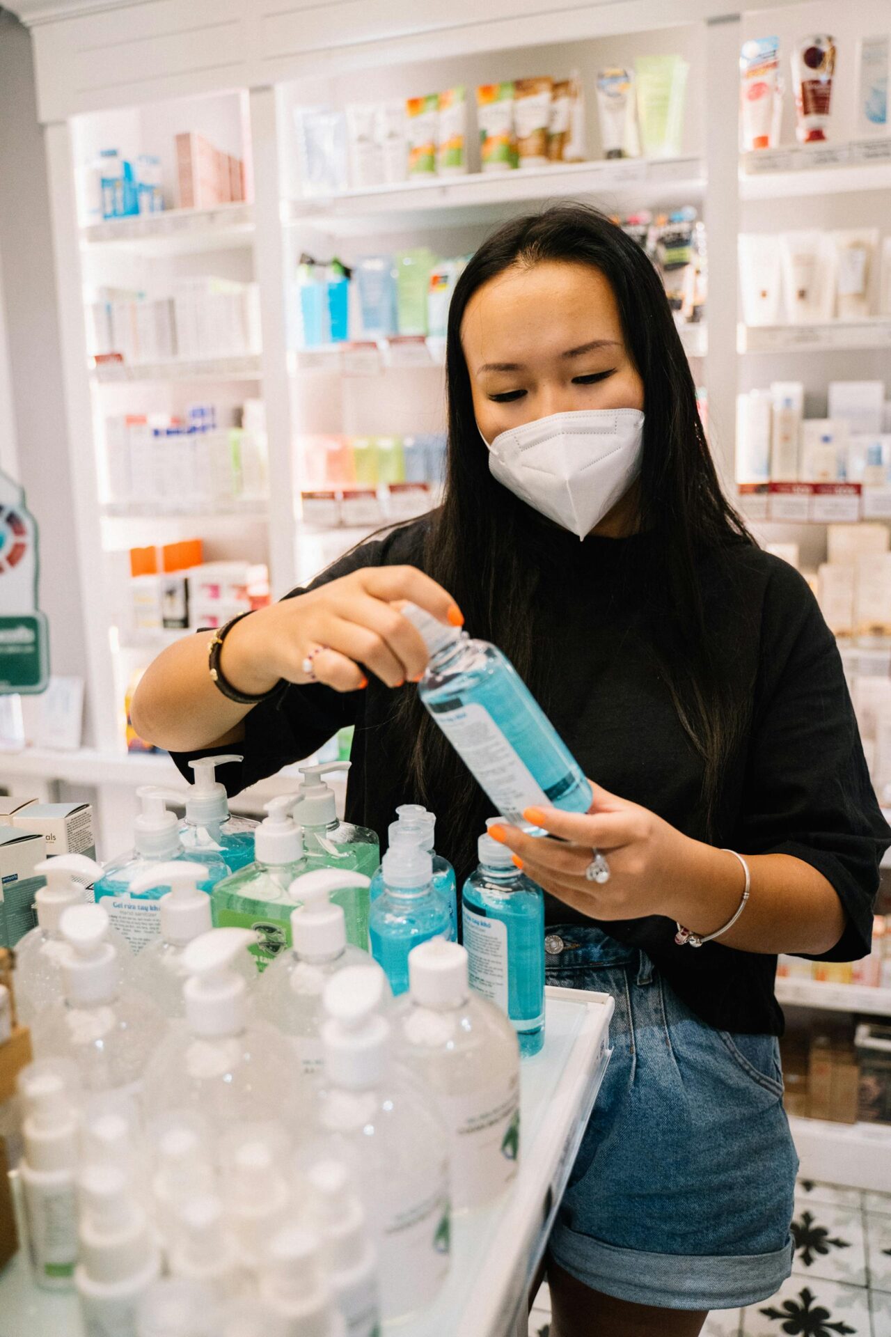 Woman in Black Shirt Holding A Bottle Of Hand Sanitize